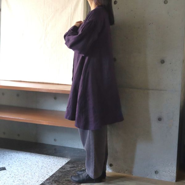 パープルのリネンチュニックとグレーのコーデュロイパンツの秋冬コーディネート全身横向き写真