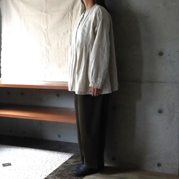 リネンブラウスとコーデュロイパンツを合わせた全身やや横向きショット。袖丈やシルエットがわかる大人ナチュラルスタイル。