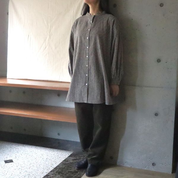 綿麻ストライプチュニックにオリーブグリーンのコーデュロイパンツを合わせた女性の全身正面コーデ写真