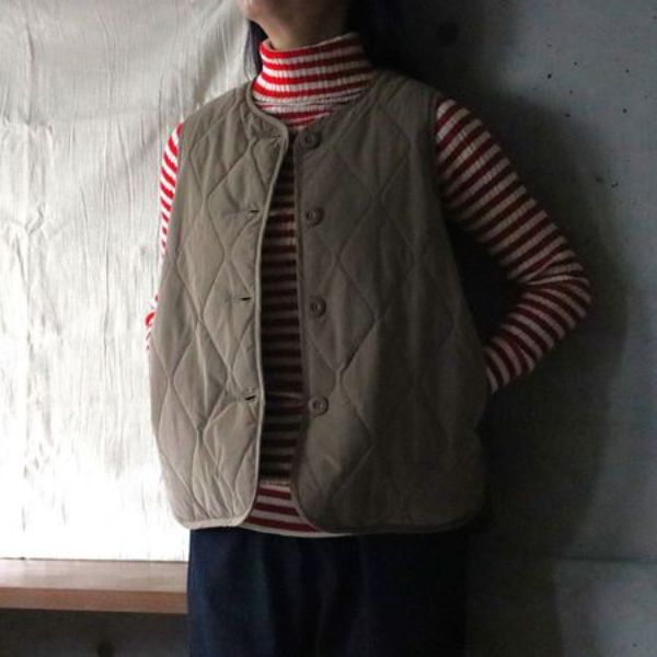 ブラウンの中綿入り万能ベストに赤白ストライプカットソーを合わせた秋冬コーデ。軽くてあたたかく、ピーチ起毛素材のやわらかな風合いが魅力。