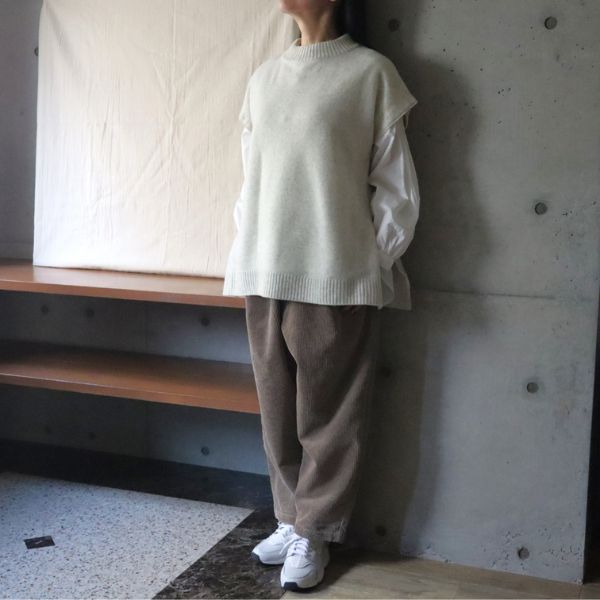オートミール色のタスマニアラムウールベストに白シャツとベージュのコーデュロイパンツを合わせた全身正面コーデ。上質ウールベストが引き立つ、上品なナチュラルスタイル。