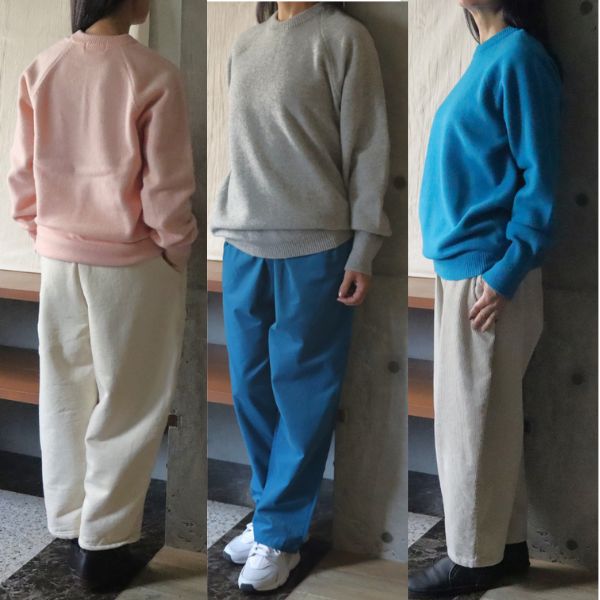 タスマニアラムプレミアム・エターナルニットのピンク、グレー、ターコイズを着た女性3名の立ち姿を並べた写真。淡色から鮮やか色まで冬ニットのカラー比較ができるイメージ。