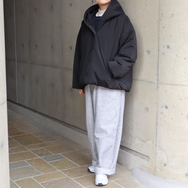 黒のピーチ起毛中綿フードショートコートの正面全身コーデ。ストライプ柄のノッポパンツとのコーデで、すっきりとナチュラル上品な大人カジュアルコーデ。