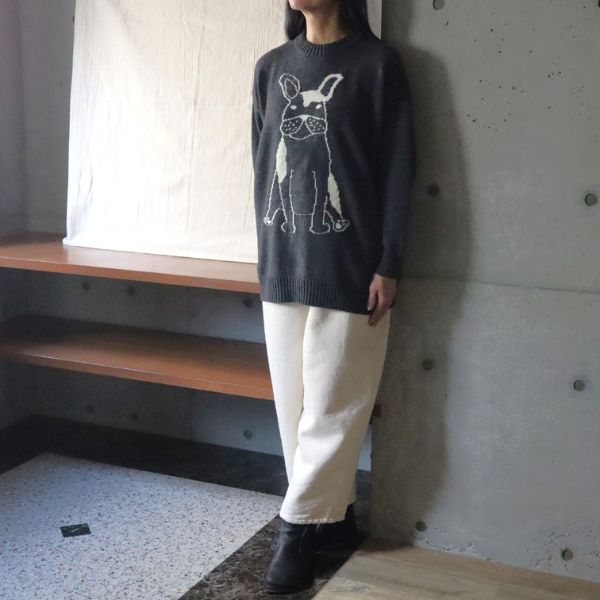 フレンチブルゆったりニットの正面全身コーデ。前身頃にちょこんと座るフレンチブルが描かれたデザイン。白いパンツと合わせて、軽やかで可愛い冬の装い。