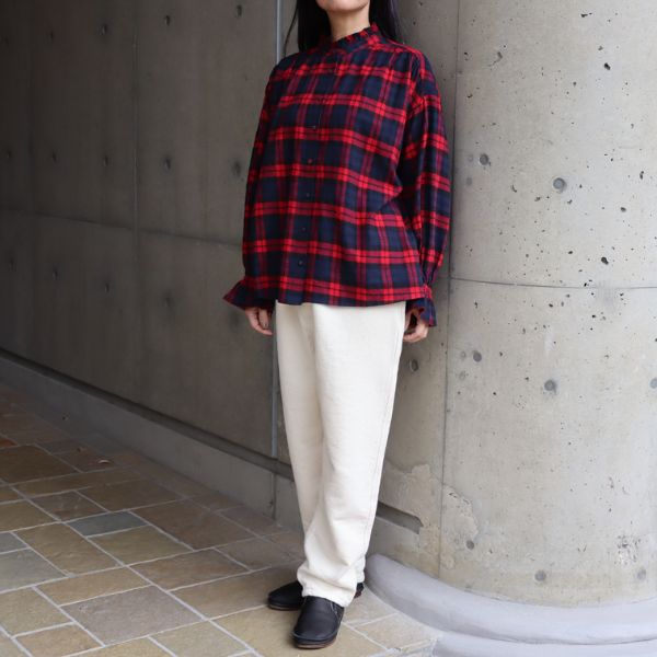 赤黒チェックブラウスとキナリ色の裏起毛デニムパンツを着た女性の冬コーデ正面全身写真