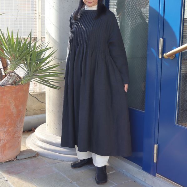 ブラックの9番手リネンラグランスリーブワンピースのインナーに、アイボリーのシルクベールハイネックを重ね、キナリの8オンスムラデニムエッグパンツを合わせた全身正面コーデ。天然素材のやさしい重ね着が、ふんわりとした大人ナチュラルな雰囲気を演出。