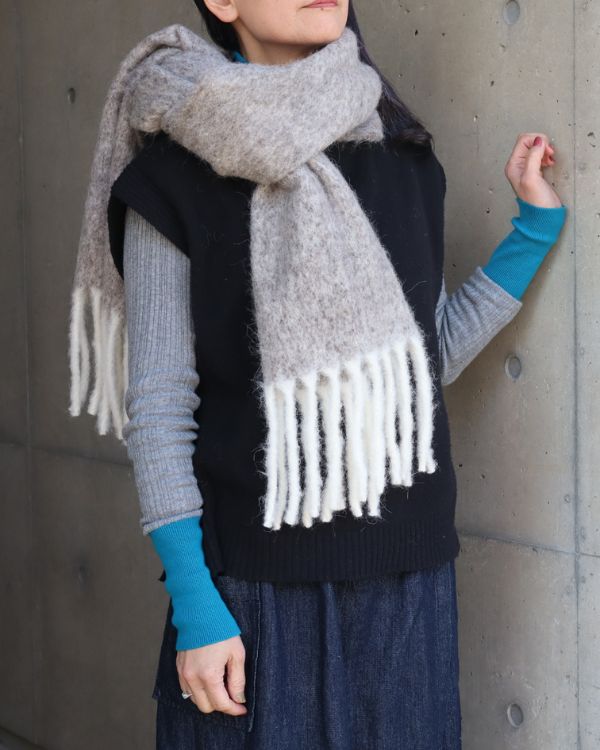 アルパカウールのフリンジマフラーを女性が首元に巻いた着用写真。起毛加工のやさしい質感とブラウンカラーの上品さが伝わる。