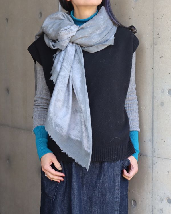 ウール×シルク真綿のニードルパンチストールを女性が首元に巻いた着用写真。軽やかな素材感と肌なじみの良さが伝わる。