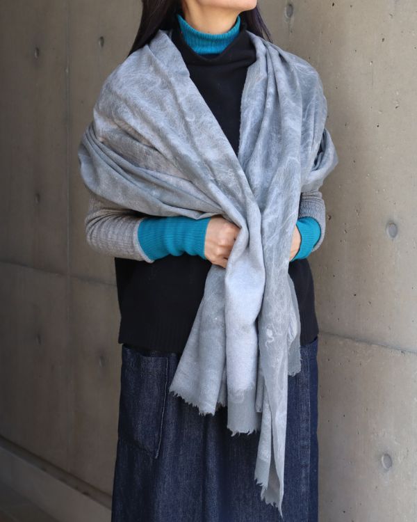 ニードルパンチ技法で仕上げたウール×真綿ストールを女性が肩に羽織った写真。大判ならではの上質な佇まいが印象的。