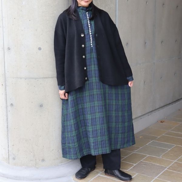 ブラックウォッチ柄の多ボタン衿付きワンピースの上に、タスマニアラム素材のブラックAラインカーディガンを重ねた全身正面写真。落ち着いた色合わせで、やさしく品のある大人ナチュラルコーデに。