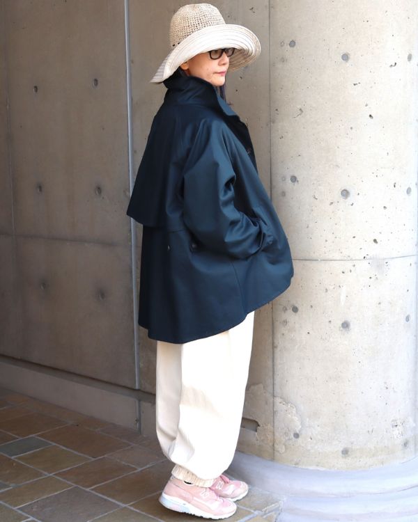 40/2コットンギャバのショートトレンチコートを着た女性の全身横向き写真。Aラインのシルエットと上品なハリ感が際立つ、大人のライトアウター。