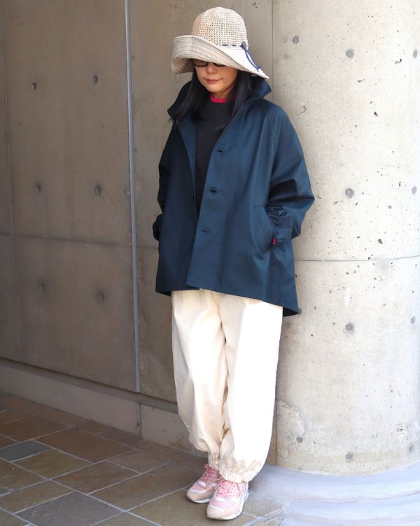 40/2ギャバ素材のブラックネイビーショートトレンチコートを着た女性の全身正面写真。キナリパンツと合わせた、大人ナチュラルな春アウターコーデ。