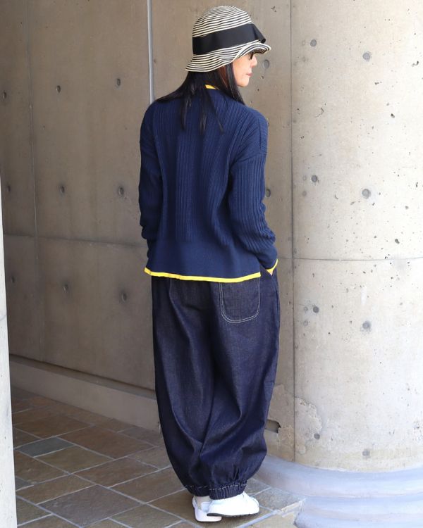 ブルーのニットとインディゴパンツを合わせた後ろ姿。軽やかで爽やかな、大人のカジュアルスタイル。