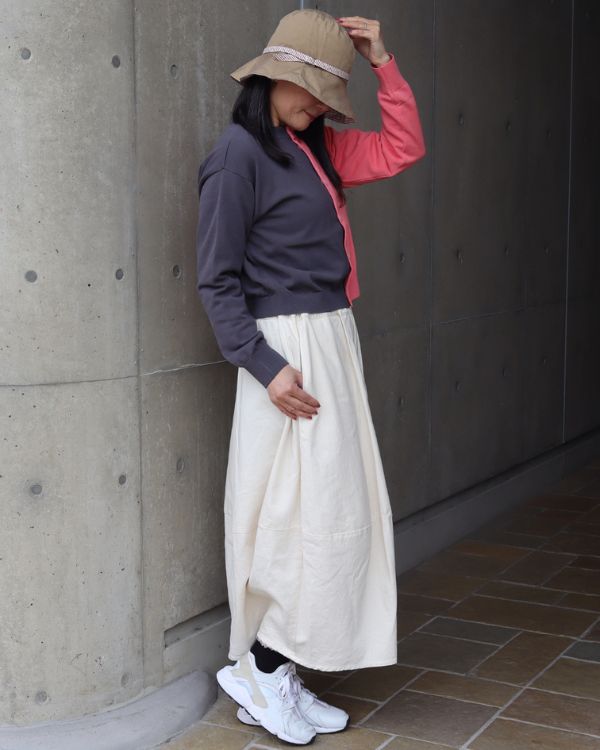 スノーコットン バイカラーニットカーディガン × 8オンスムラデニム 春コーデ。エッグスカートを合わせた全身横向き写真。