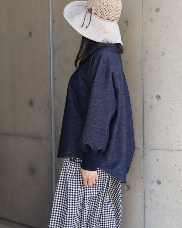 インディゴのデニムニットトレーナーのサイドシルエットとリラックス感がわかる横向き腰上写真