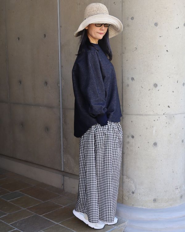 インディゴのデニムニットトレーナーと黒白チェック柄ギャザースカートのシルエットがわかる全身横向きコーデ写真