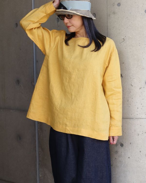 前後着ノーカラーブラウスのプルオーバー面を前に着用し、8オンスムラデニムパンツと合わせたリラックス感のある大人カジュアルスタイル。