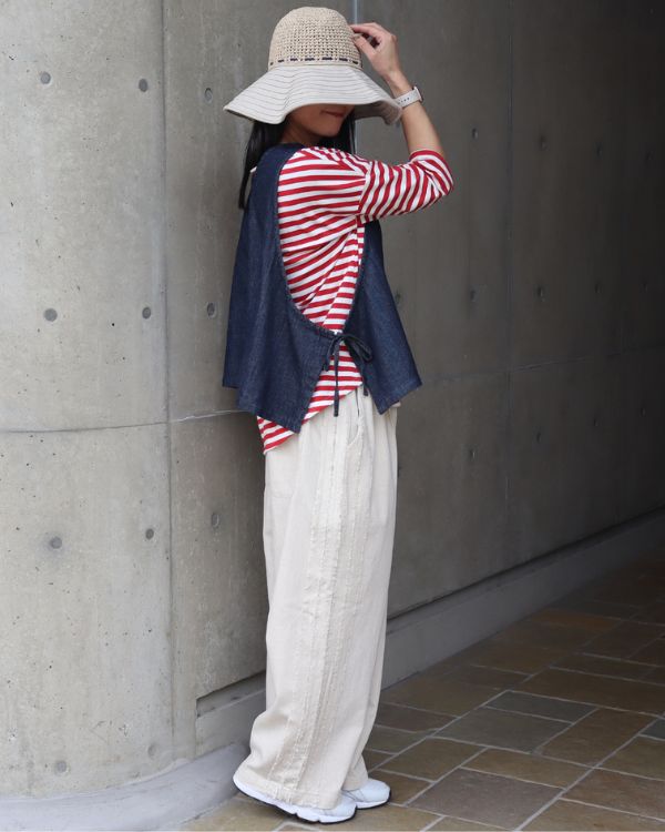赤白ボーダーシャツとインディゴベストの重ね着コーデ横向き全身｜サイドリボンの脇ディテール｜名古屋覚王山コッピアーナ
