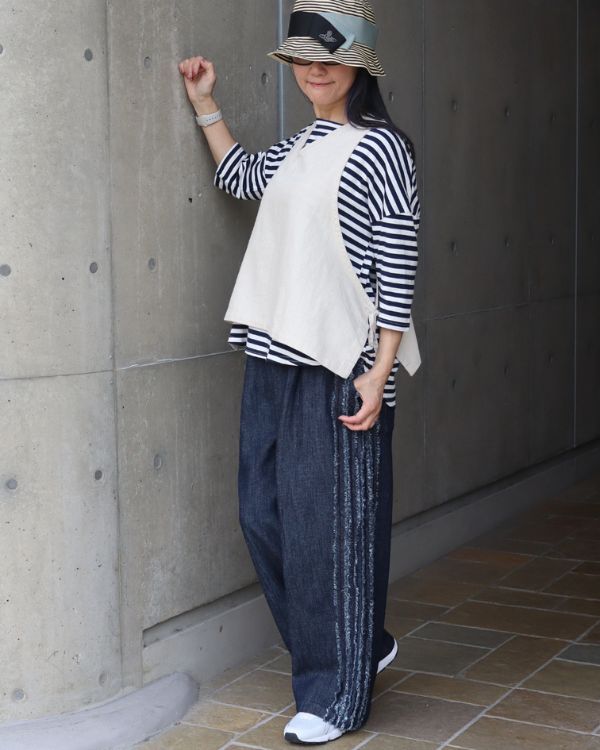 青白ボーダーシャツとナチュラルベストの重ね着コーデ斜め横全身｜大人ボーダー春スタイル｜名古屋覚王山コッピアーナ