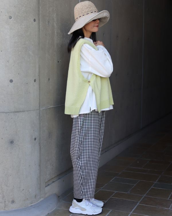 コットンハイゲージニットサイドオープンツーウェイベストのライトグリーンとチェック柄エッグパンツの春コーデ全身横向き|名古屋覚王山コッピアーナ