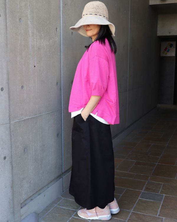 名古屋・覚王山のセレクトショップ コッピアーナ｜白の猫Tシャツとコスモスカラーのカーディガンにブラックベイカースカートを合わせた横向きシルエットがわかる春の大人カジュアルコーデ