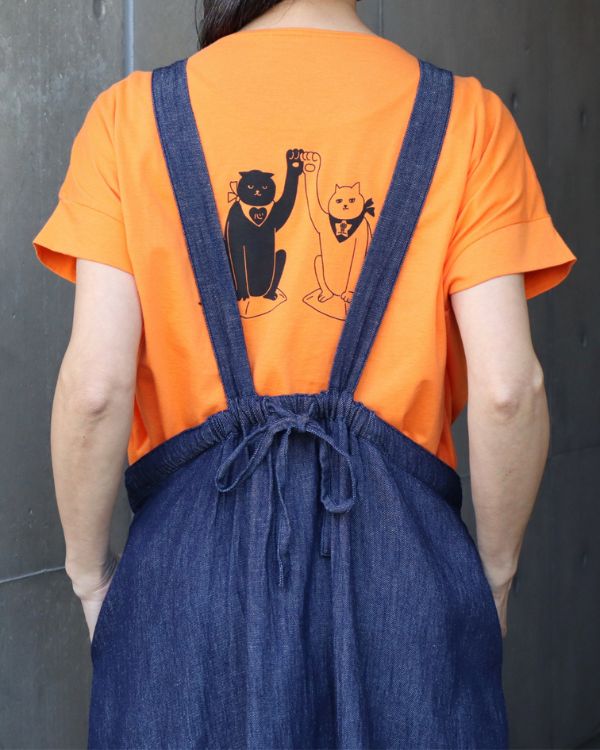 背中にひょっこり見える招き猫プリントが可愛い2wayTシャツのディテール ジャンパースカートとの重ね着コーデ 大人の女性に似合うさりげない可愛さ
