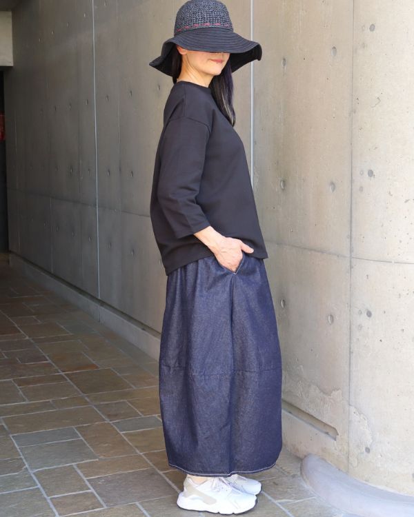 名古屋覚王山コッピアーナの黒7分袖トップスと8オンスムラデニムエッグスカートの横姿コーデ写真。丸みのあるシルエットが特徴。