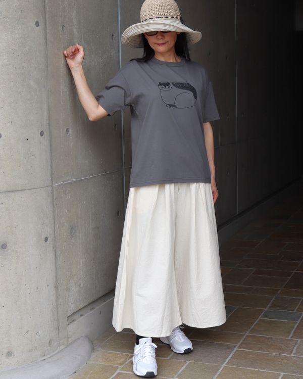 名古屋覚王山のセレクトショップ コッピアーナで紹介するカーキグレーの猫プリントTシャツとアイボリーのA型ペンギンパンツを合わせた全身コーデ写真。