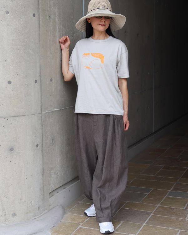 ライトグレーのemoemoコラボ猫Tシャツにチャコールのギャザーポケットタックパンツを合わせた名古屋覚王山コッピアーナの全身コーデ写真。
