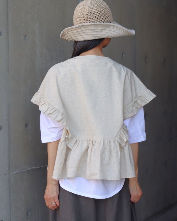コットンラミー素材のラッフルブラウスを後ろ姿から撮影した初夏コーデ 名古屋 覚王山 コッピアーナおすすめの重ね着スタイル