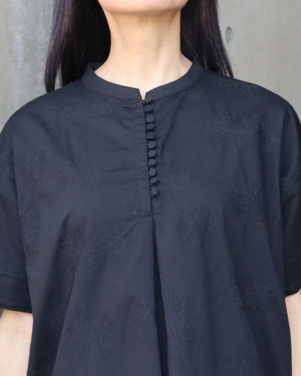 コットンポプリンダリア刺繍多釦半袖ブラウスのダリア刺繍を近くから撮影した写真。ブラックの綿100％ポプリン生地に繊細な刺繍が映え、装いに上品なアクセントを添えてくれます。
