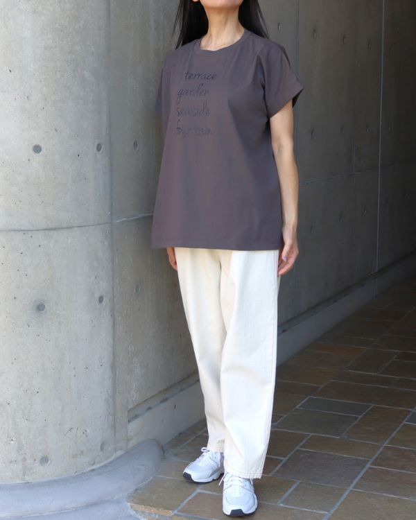 コッピアーナ（名古屋・覚王山）おすすめのコットンジャージーロゴプリント半袖Tシャツ チャコールの着用イメージ。大人のカジュアルスタイルになじむ落ち着いたカラーで、パンツにもスカートにも合わせやすいデザインです。

