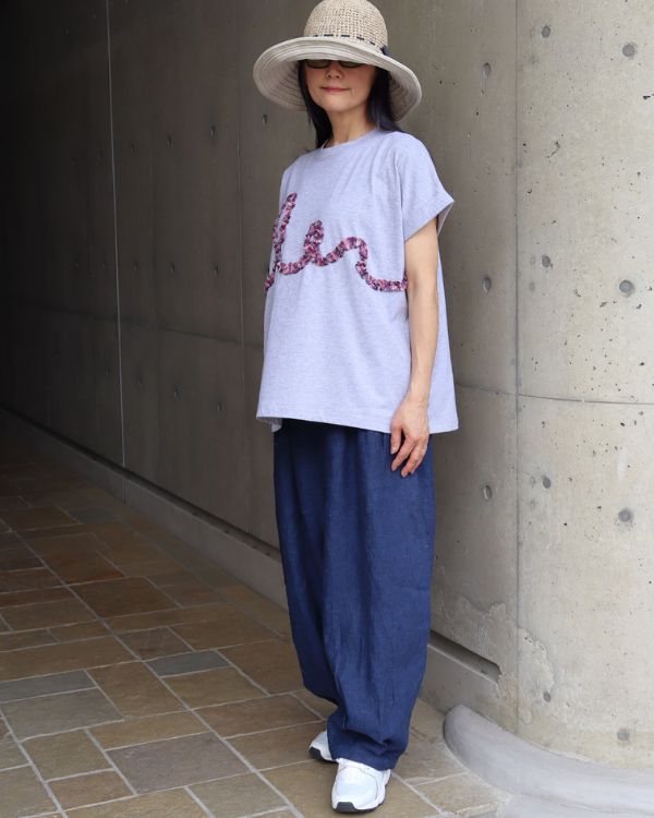 名古屋・覚王山のコッピアーナでご紹介しているコットンジャージーチェックフリル半袖Tシャツのグレー着用イメージ。コットン100％のやわらかな素材と立体的なフリルが映え、夏の終わりから初秋まで心地良く楽しめるコーディネートです。
