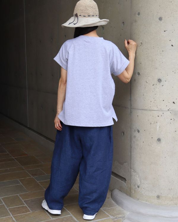 名古屋・覚王山のコッピアーナがおすすめするコットンジャージーチェックフリル半袖Tシャツのグレー着用イメージを後ろから撮影。すっきりとしたシルエットで、パンツにもスカートにも合わせやすく、毎日の装いを上品に彩る一枚です。