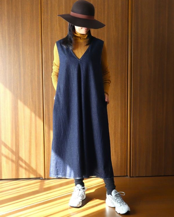 名古屋・覚王山のセレクトショップ コッピアーナで紹介する、インディゴの8オンスムラデニムジャンパースカートを着用した全身正面写真。軽やかなデニム素材で、季節をまたいだ自然体の着こなしを楽しめます。
