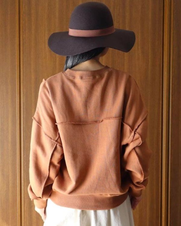 名古屋・覚王山のセレクトショップ、コッピアーナが紹介する秋の着こなし。ブラウンの切替スウェットを後ろから撮影し、ゆったりとしたシルエットを見せています。クリーム色の14Wコーデュロイエッグスカートと合わせた、自然体で心地よく過ごすためのナチュラルコーデです。