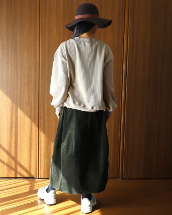 名古屋・覚王山のコッピアーナがおすすめする秋のナチュラルカジュアル。グレージュのスーパーストレッチベロアワッフルPOとカーキの綿100％コーデュロイエッグスカートを後ろから見た写真で、ゆったりとした着用感と丸みのあるシルエットがわかります。